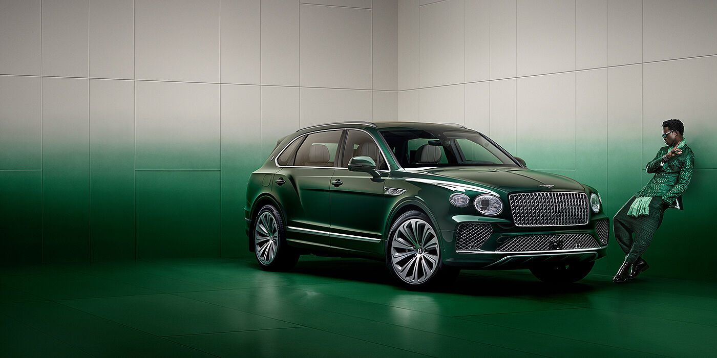 Bentley Bristol Wisdom K leans against wall next to Bentley Bentayga Extended Wheelbase Atelier Edition SUV in Light Emerald green paint